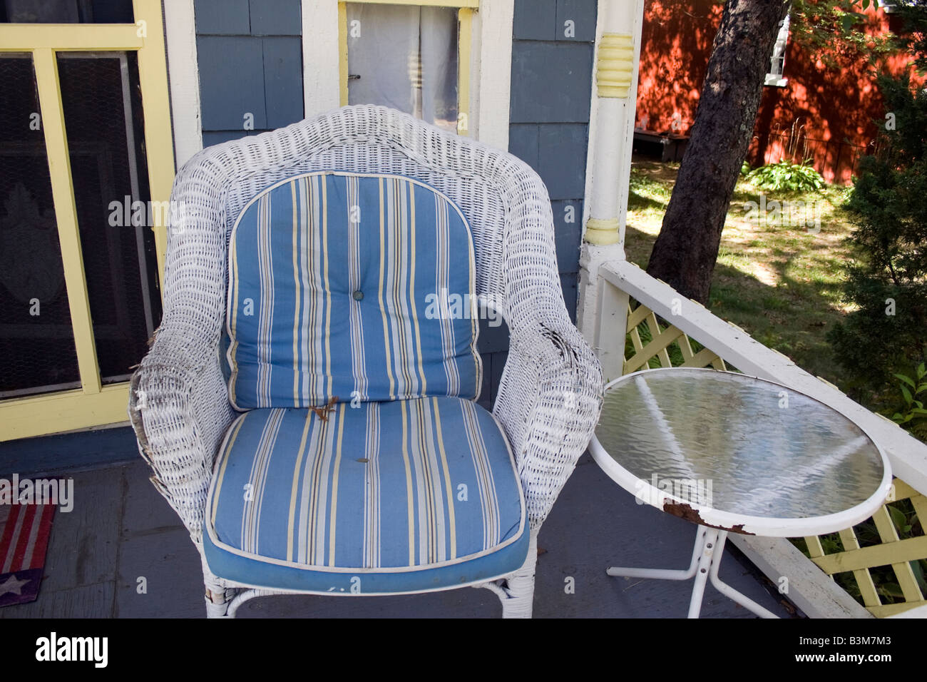 An old white cane chair on the verandah of a gingerbread house in Martha s Vineyard Stock Photo
