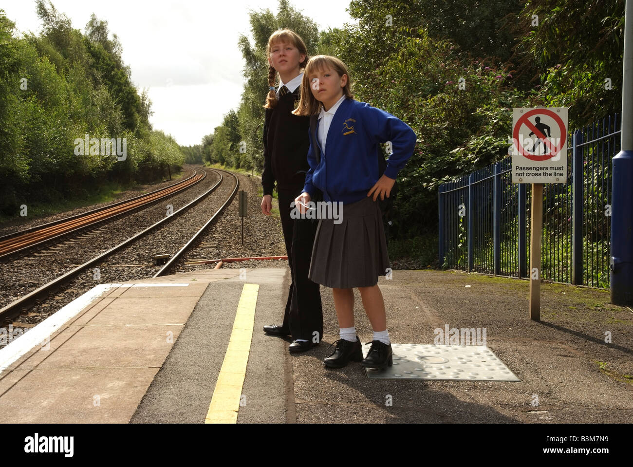 Young girls waiting for their train on a railway station platform ...