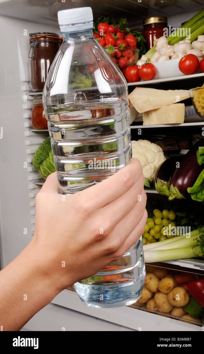 MAN TAKING BOTTLE OF MINERAL WATER FROM REFRIGERATOR Stock Photo Alamy