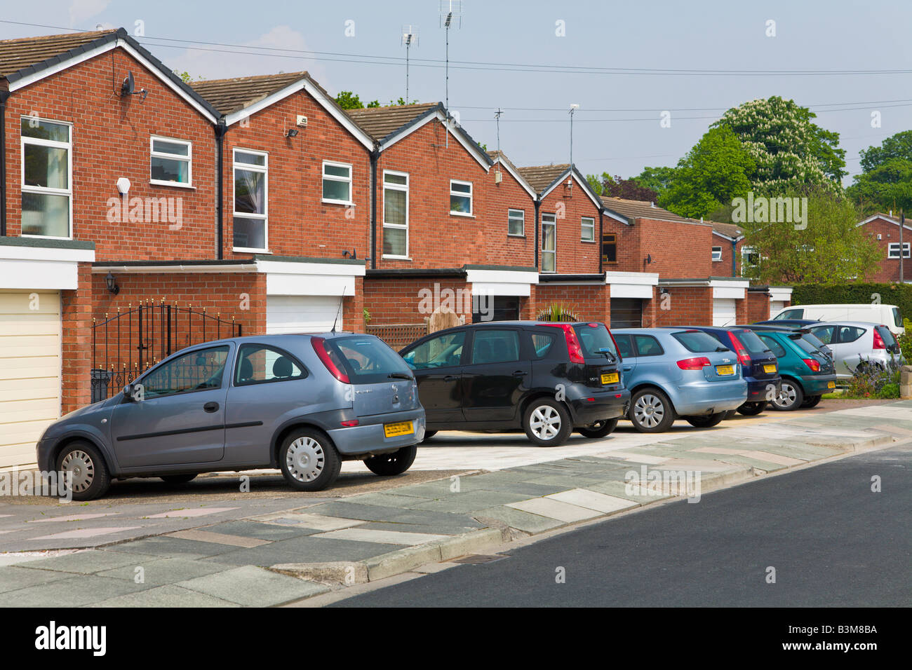 Row of parked small family cars, Modern housing estate, Wirral, England Stock Photo