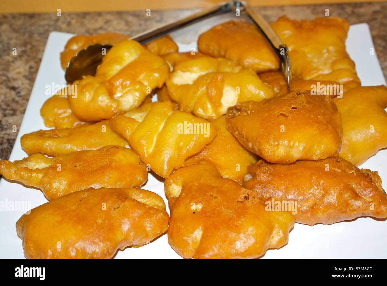 Deep fried halibut fillet in golden crisp batter on a big serving plate