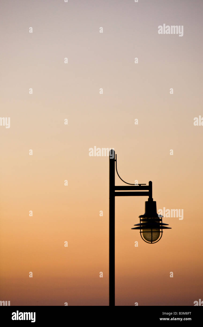 Orange sunset with silhouette of a lamppost. Stock Photo