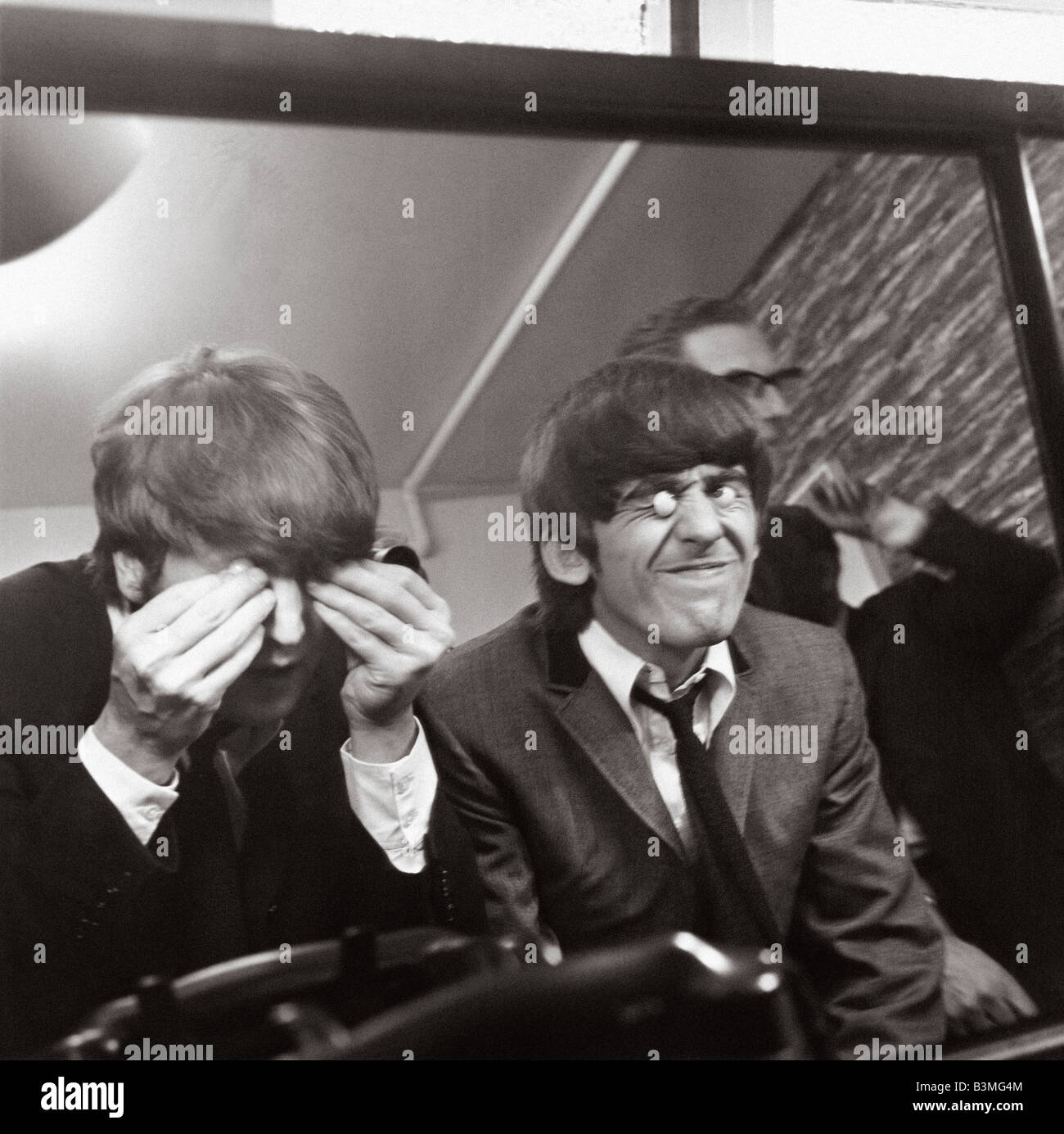 JOHN LENNON at left and George Harrison at London's Madame Tussauds waxworks in  March 1964 Stock Photo