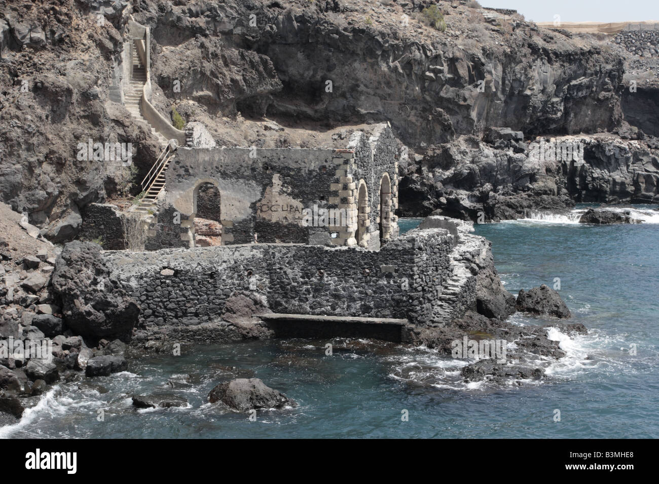 The ruins of an old pumphouse at the base of the cliff where fresh spring water was pumped up to the village of Aguadulce, Tenerife Stock Photo