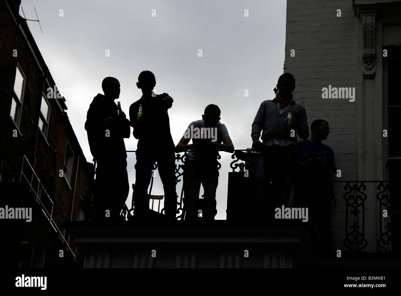 Men watching street below  from balcony Stock Photo