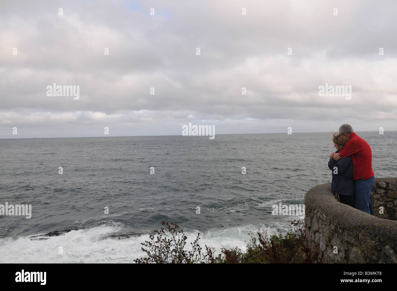 A couple looking out to sea in Falmouth, Cornwall, UK Stock Photo