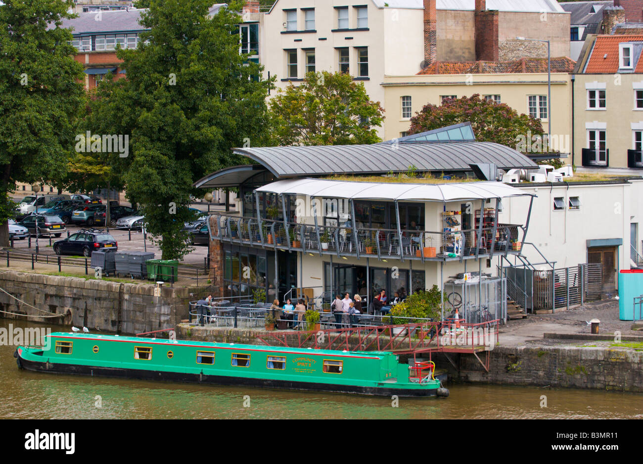 Narrowboat moored next to modern restaurant pub in Bristol Docks England UK Stock Photo