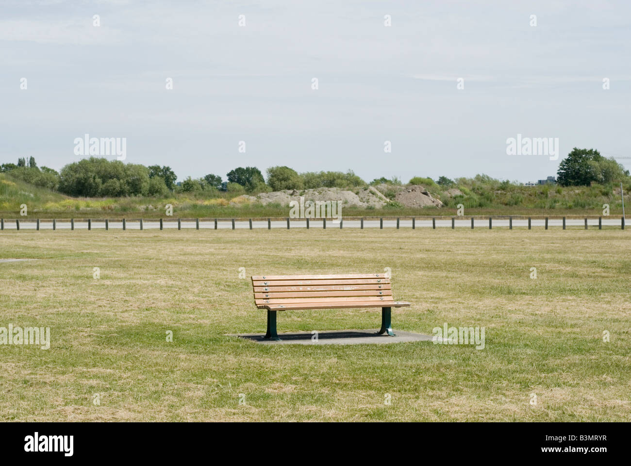 A park bench in a grass field sits empty on a hot summer day Richmond ...