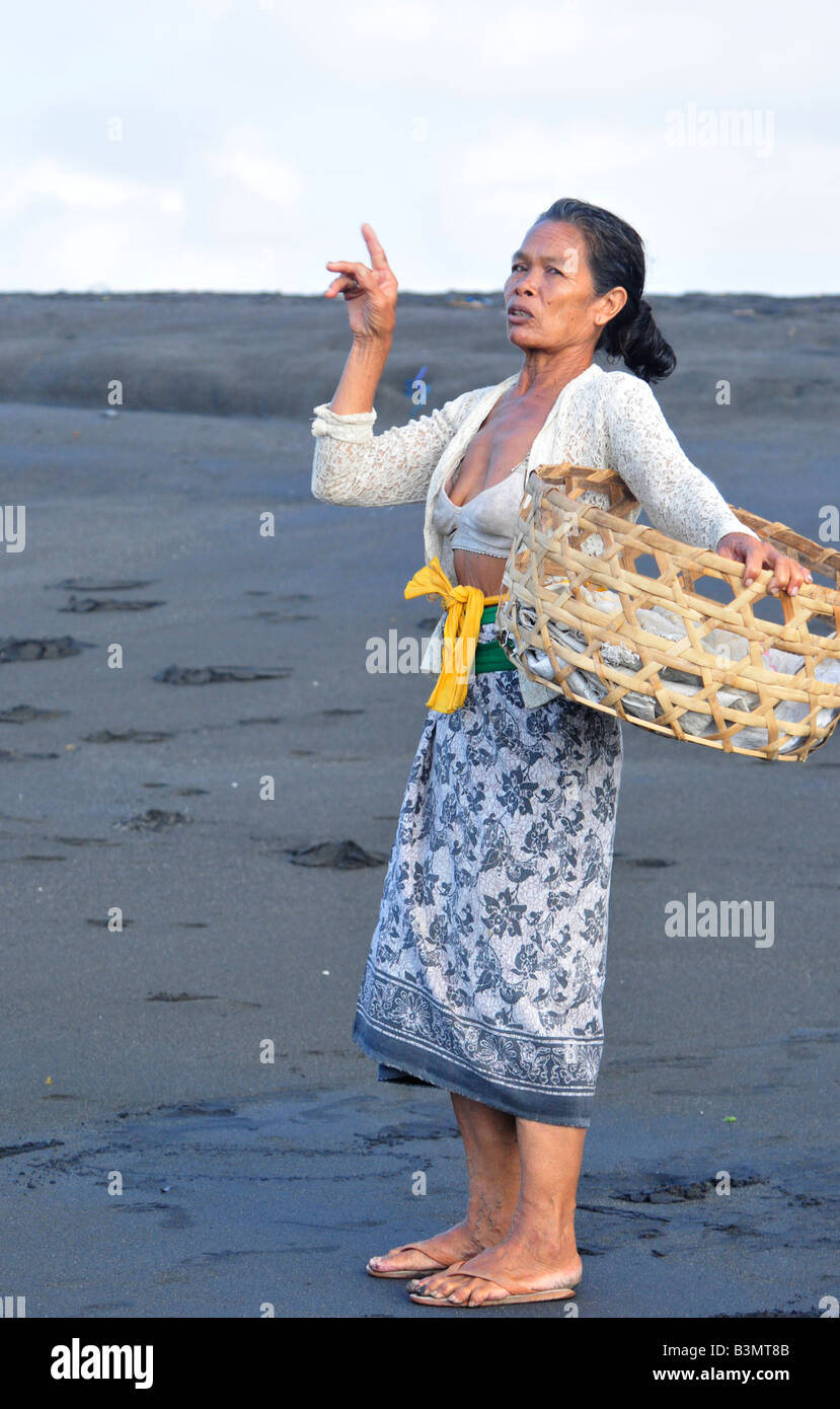 lady at beach , praying and giving offerings, cremation ritual , bali , republic of indonesia Stock Photo