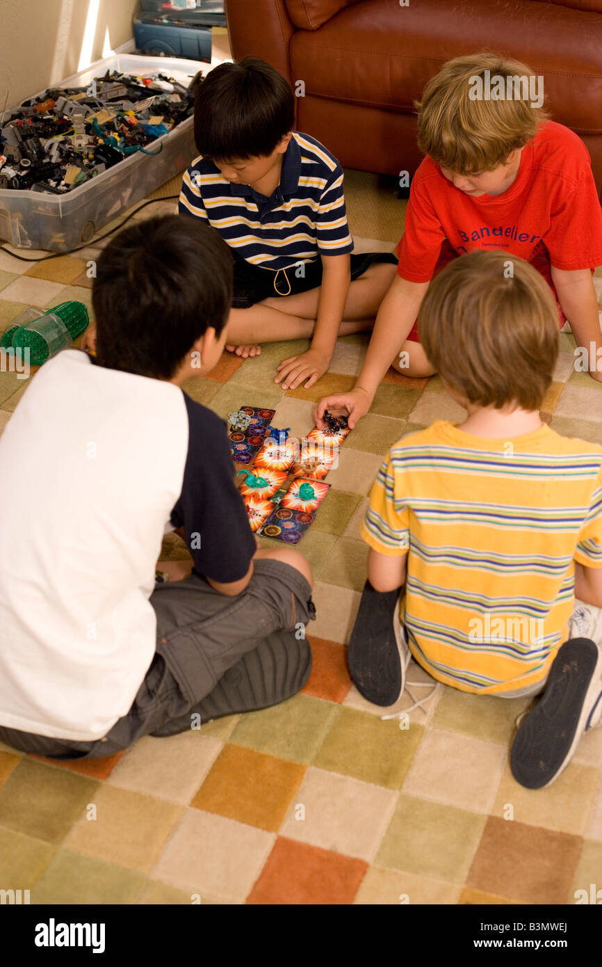 four elementary age boys play Bakugan game at home Stock Photo