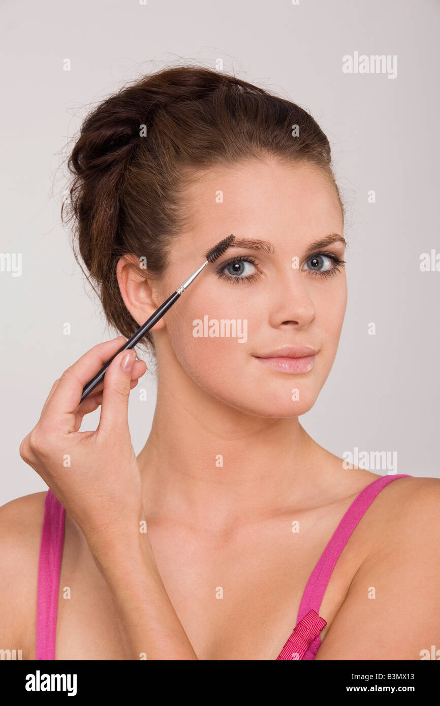 Young woman using an eyebrow pencil, portrait Stock Photo Alamy