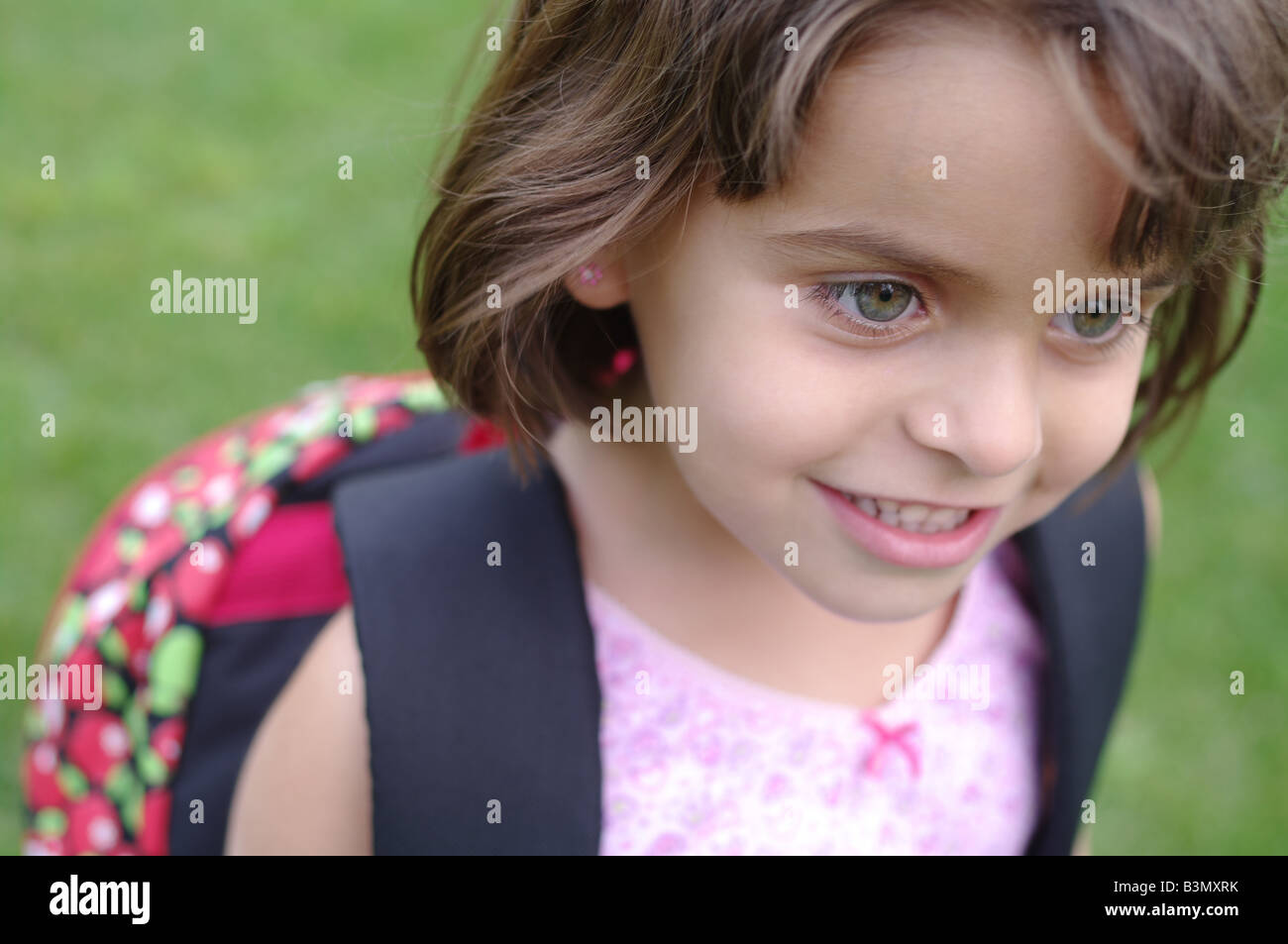 Smiling 5 years old girl with backpack waiting for the start of