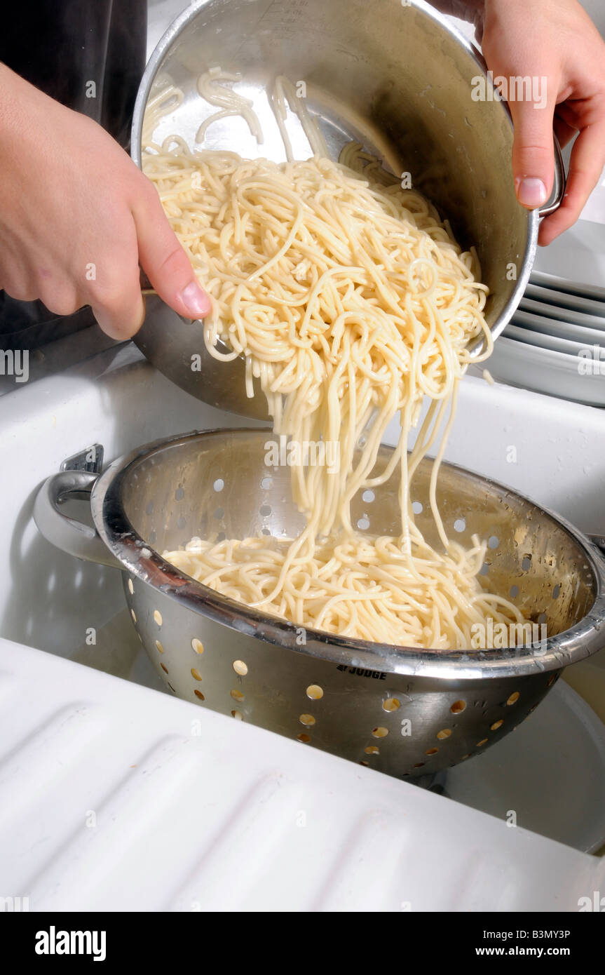 MAN DRAINING SPAGHETTI INTO COLLANDER Stock Photo Alamy