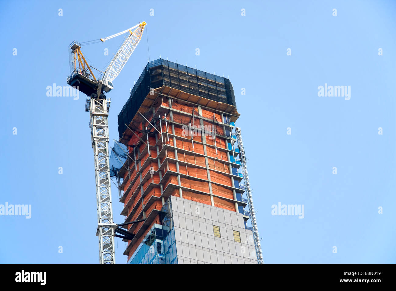 Skyscraper In Construction Tall skyscraper under construction with crane Stock Photo - Alamy