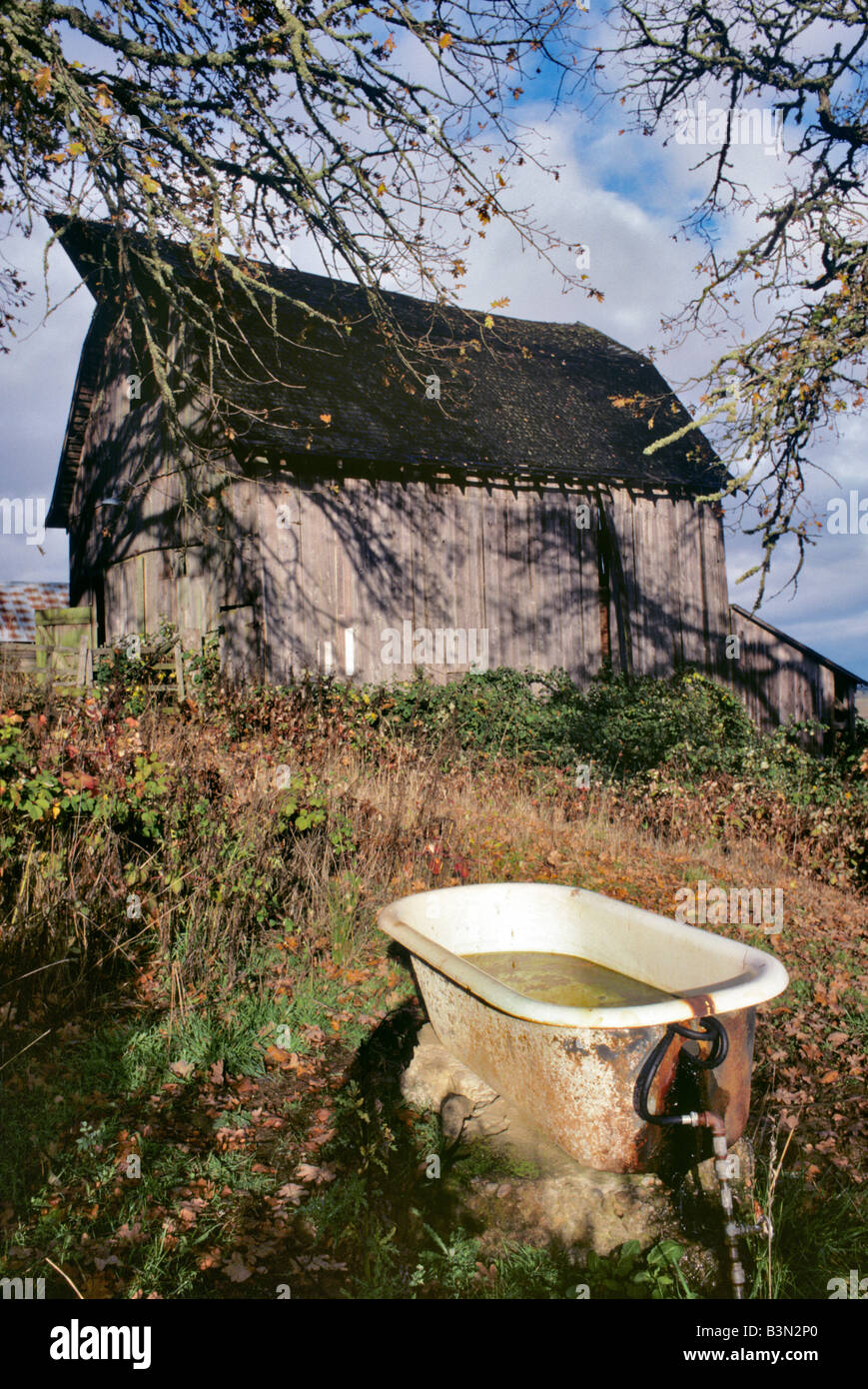 Old barn with bathtub water trough Near Monroe Oregon Stock Photo