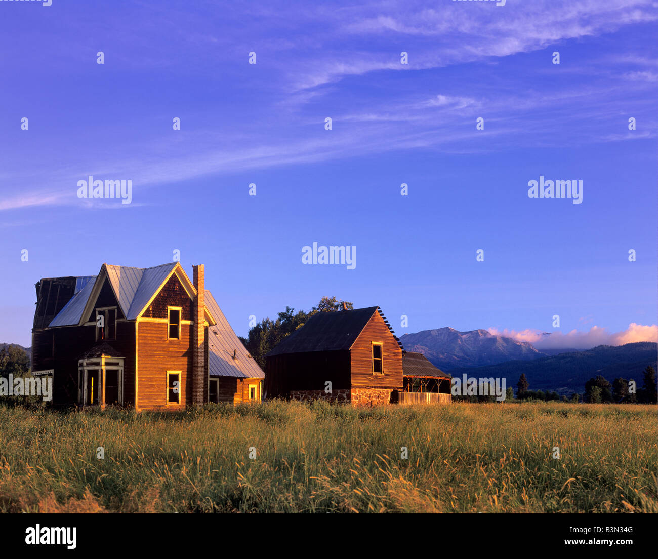 Abandoned homestead and Wallowa Mountains Near Halfway Oregon Stock Photo