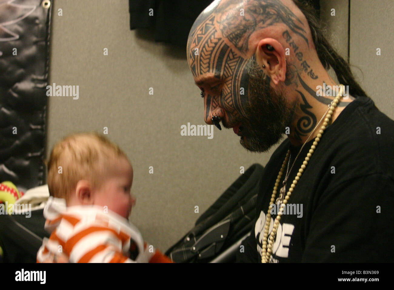 tattooed man at London tattoo show 07 with baby Stock Photo