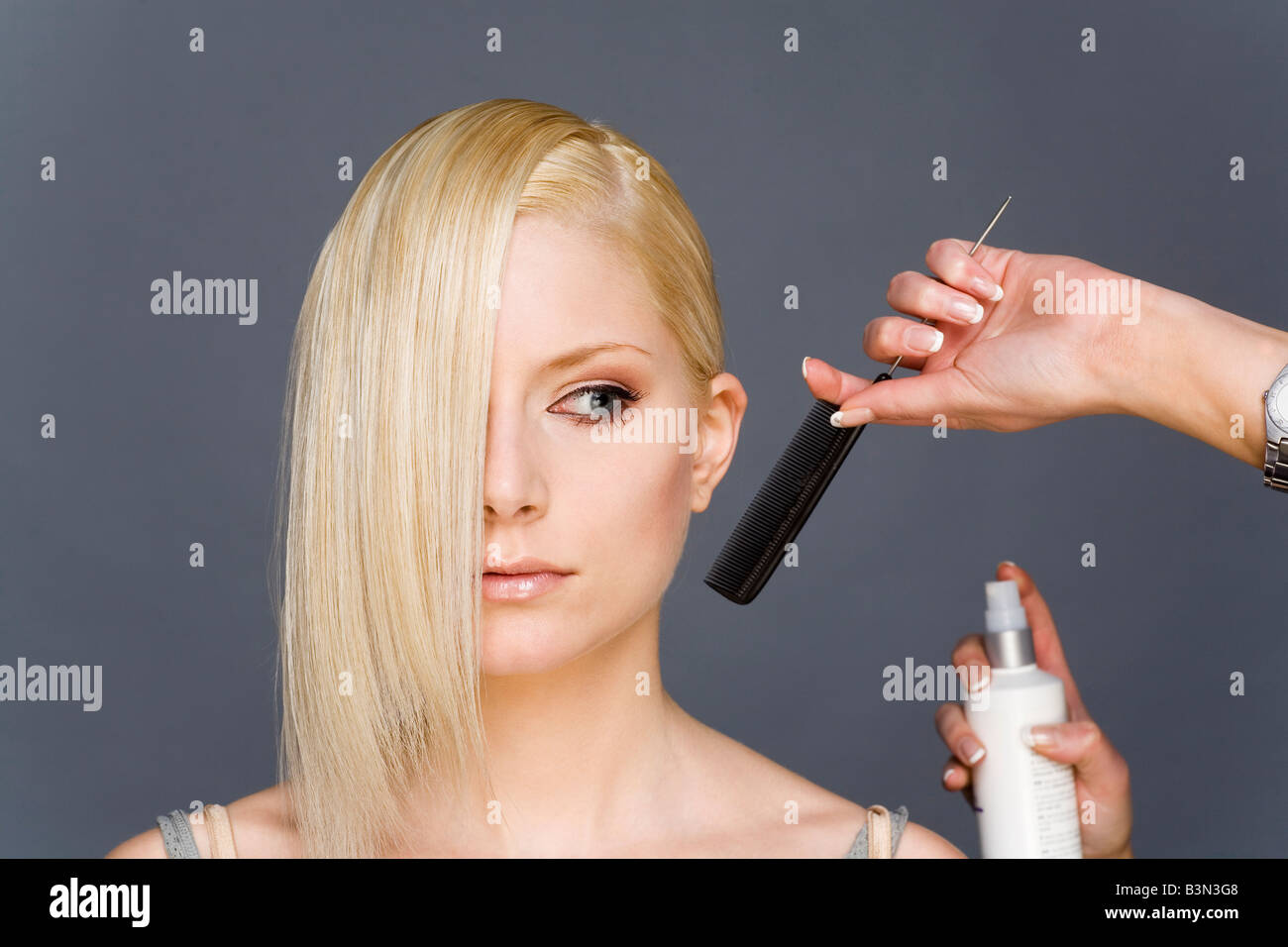 Hair stylist styling woman's hair Stock Photo Alamy