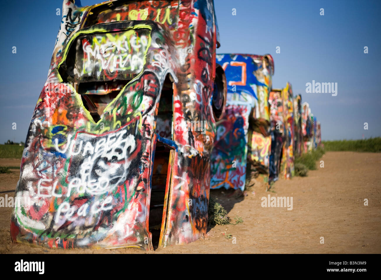 Cars stuck in the ground and spray painted with graffiti on the side of
