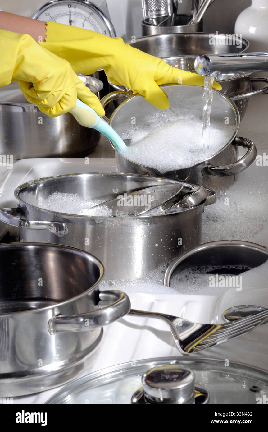 WASHING POTS AND PANS WEARING RUBBER GLOVES Stock Photo Alamy