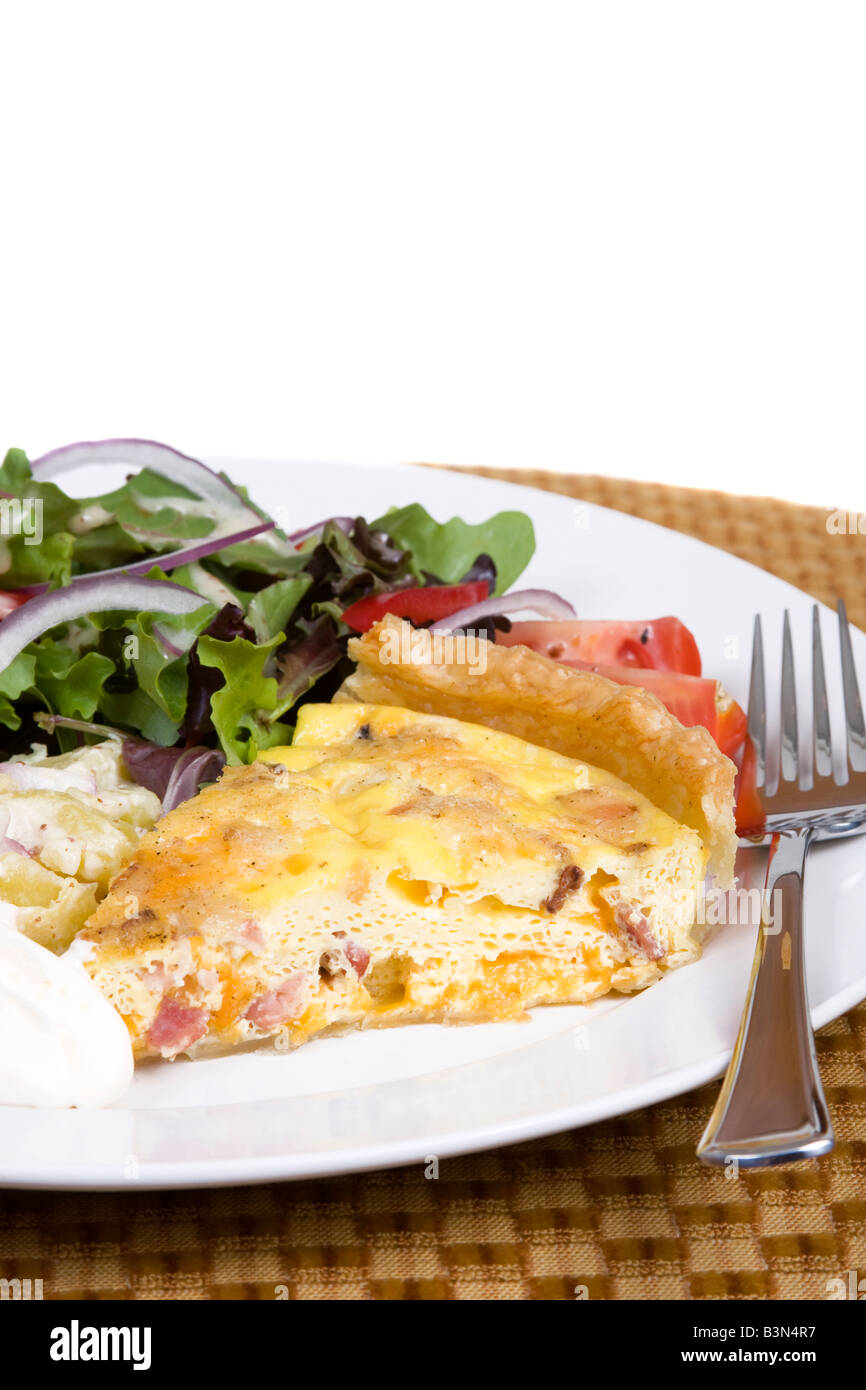 Quiche Lorraine with fresh salad on a white plate Stock Photo