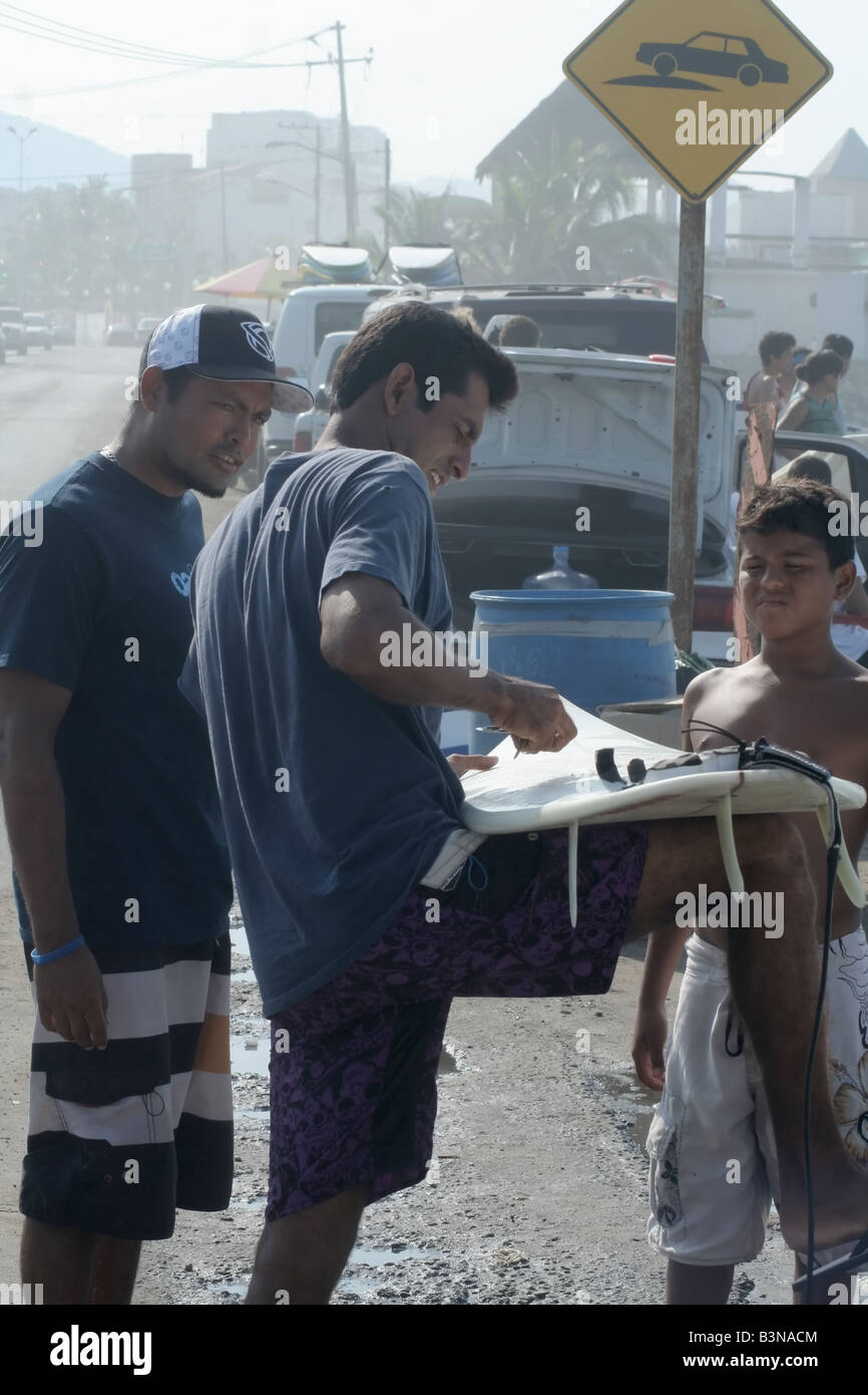 Some surfers prepping and waxing their surfboards Stock Photo Alamy