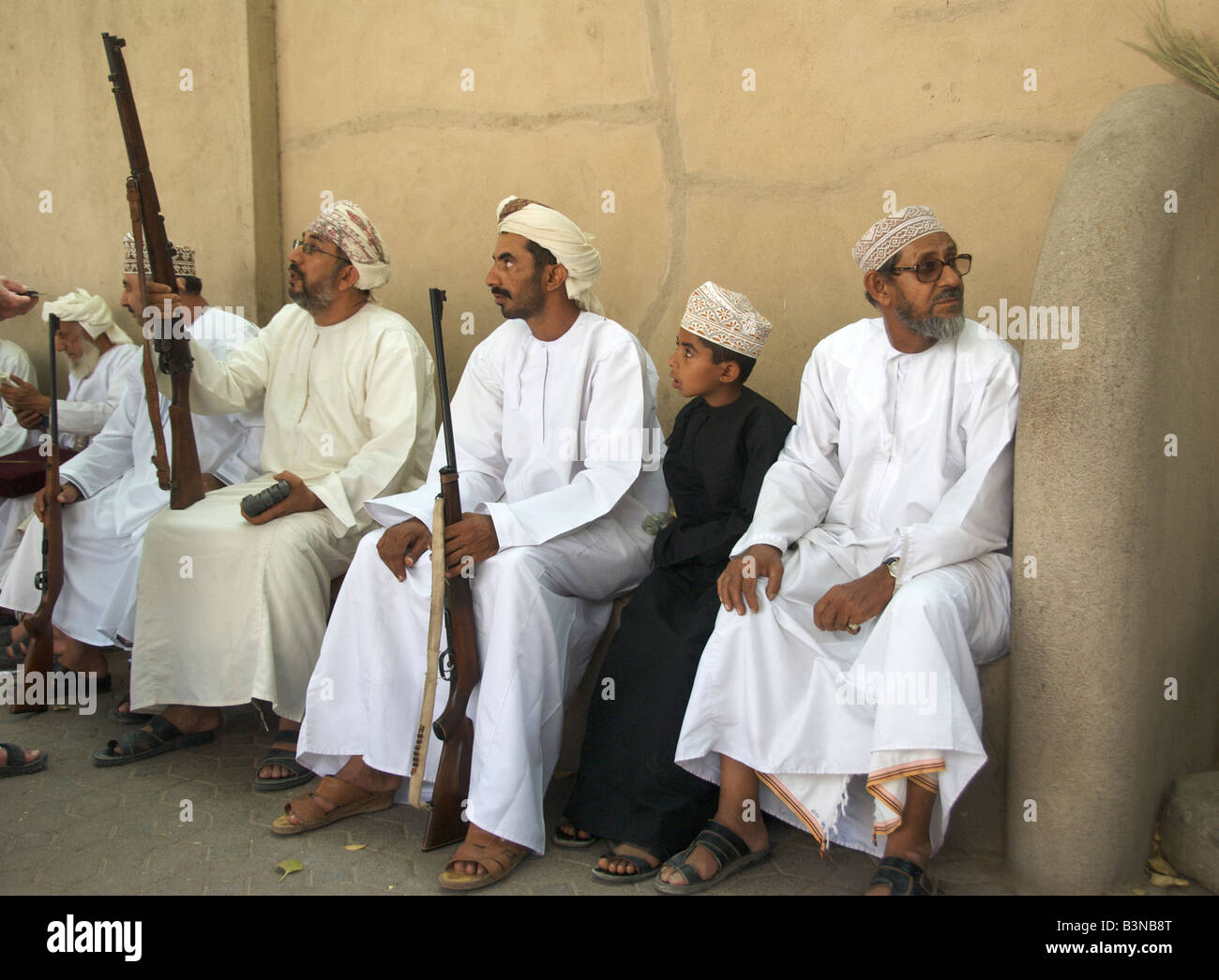 Group of seated men with rifles Nizwa Al Dakhiliyah Region Sultanate of Oman Stock Photo