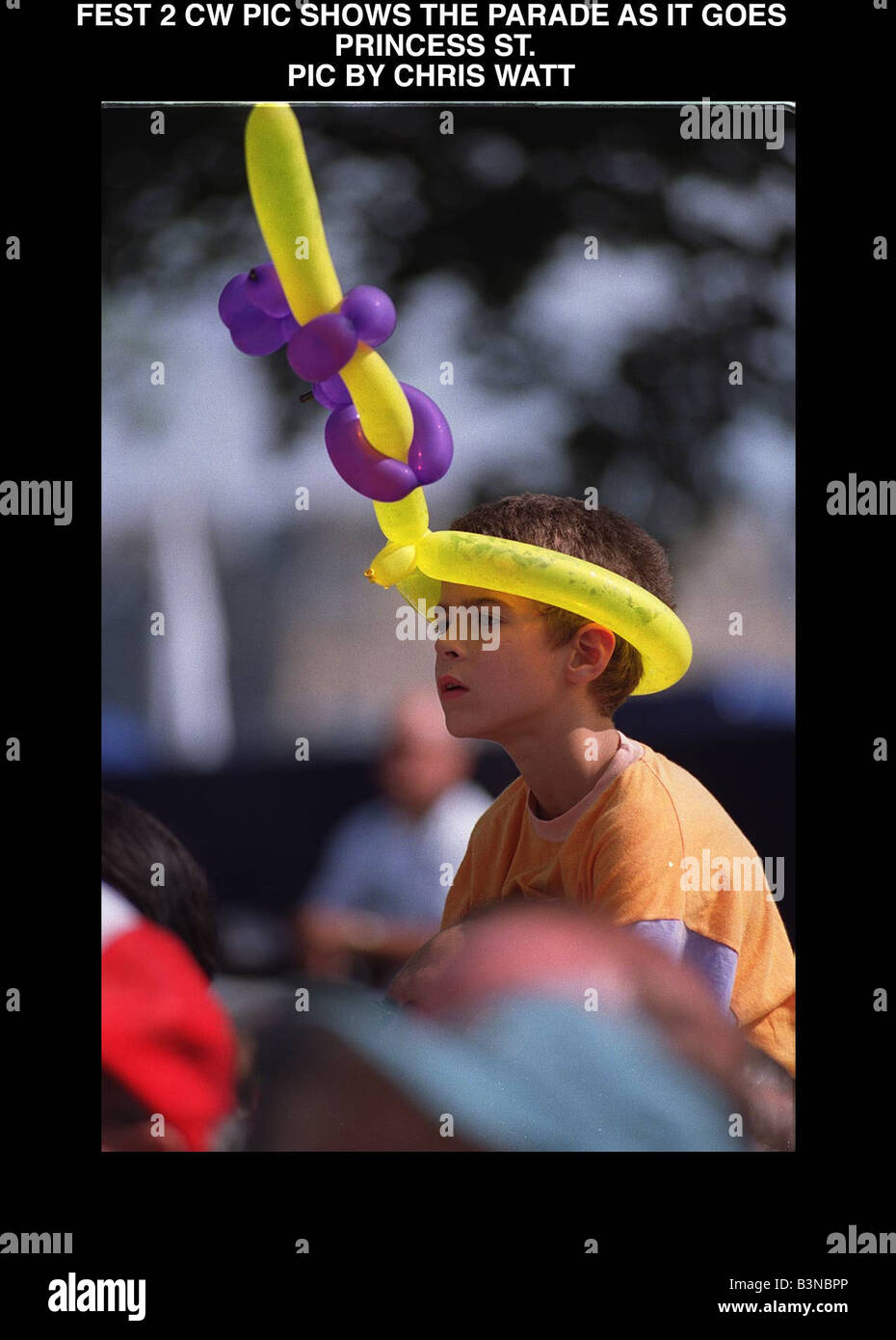 Edinburgh festival parade august 1997 Small boy with hat made of balloons animal shapes watching cavalcade procession Stock Photo