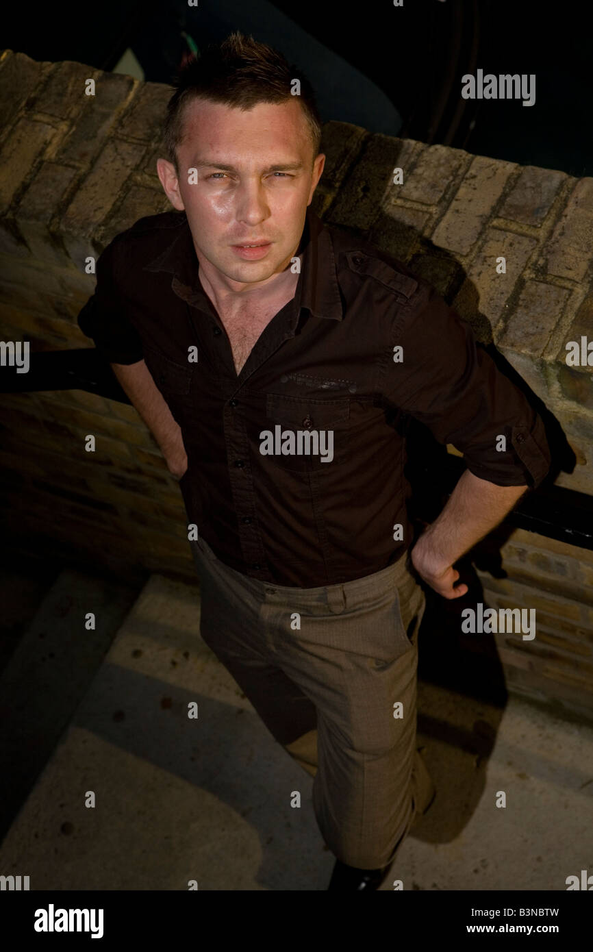 a portrait of a young handsome business man male posing and looking at ...