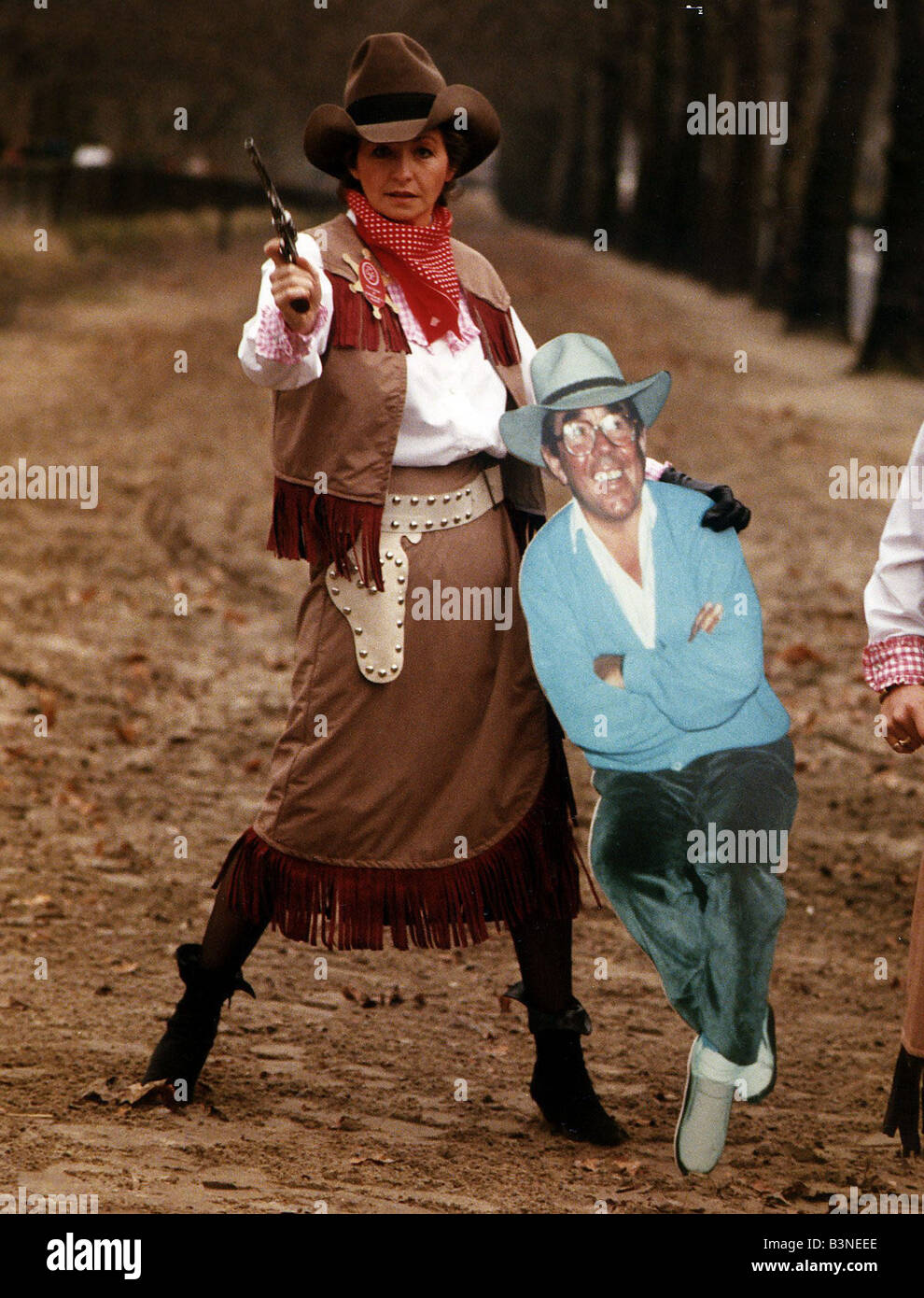 Sue Lawley TV Presenter dressed as a cowgirl with Hat and Gun holding a cardboard cutout of Ronnie Corbett January 1990 Stock Photo