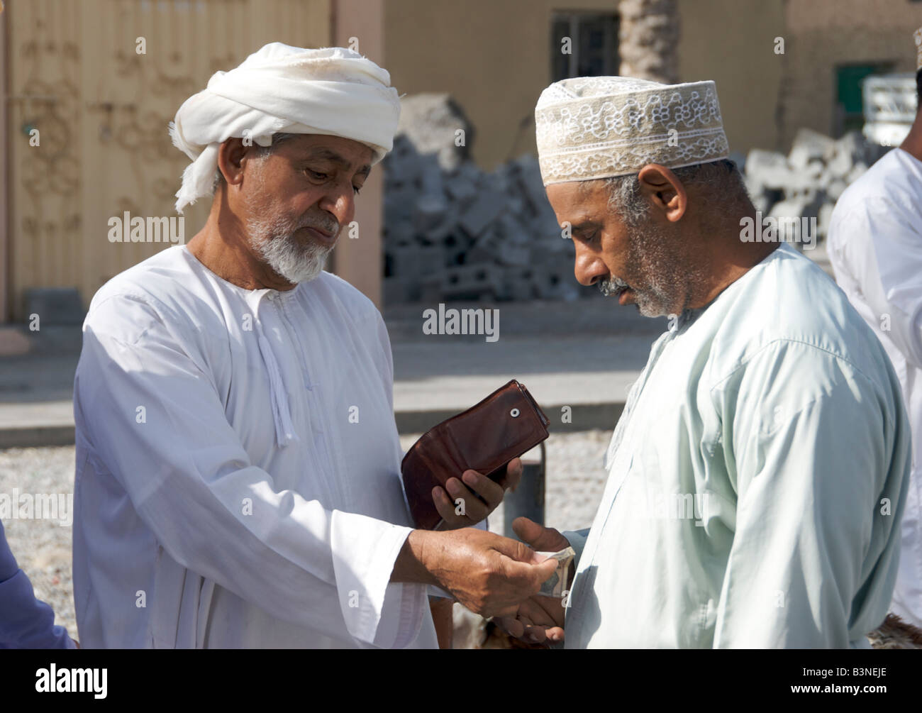Two men buying and selling livestock souq or market Nizwa Al Dakhiliyah Region Sultanate of Oman Stock Photo