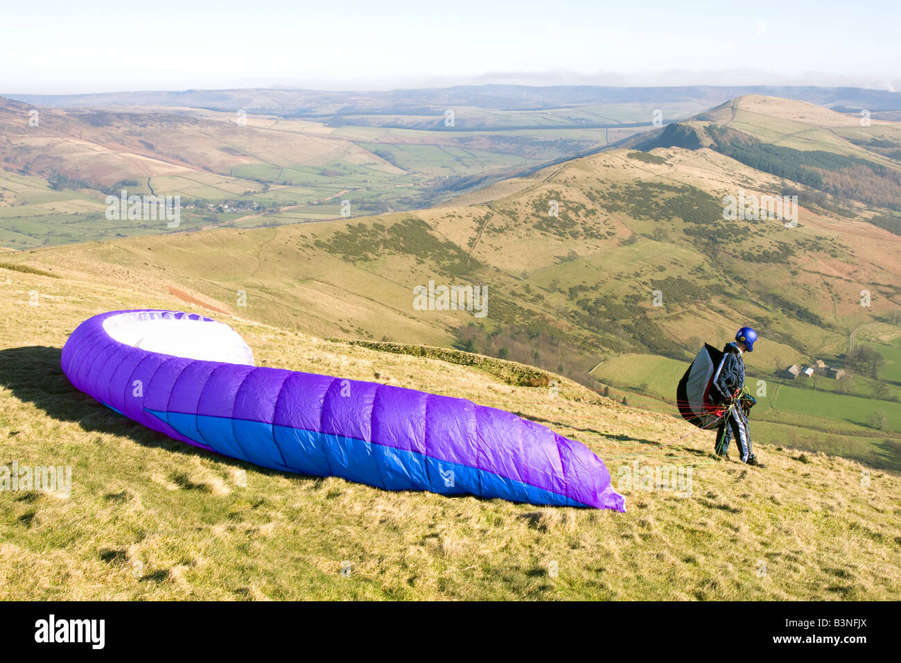 paraglider waiting for the wind to take off on top of mam tor in the english peak district with the loosehill ridge behind Stock Photo