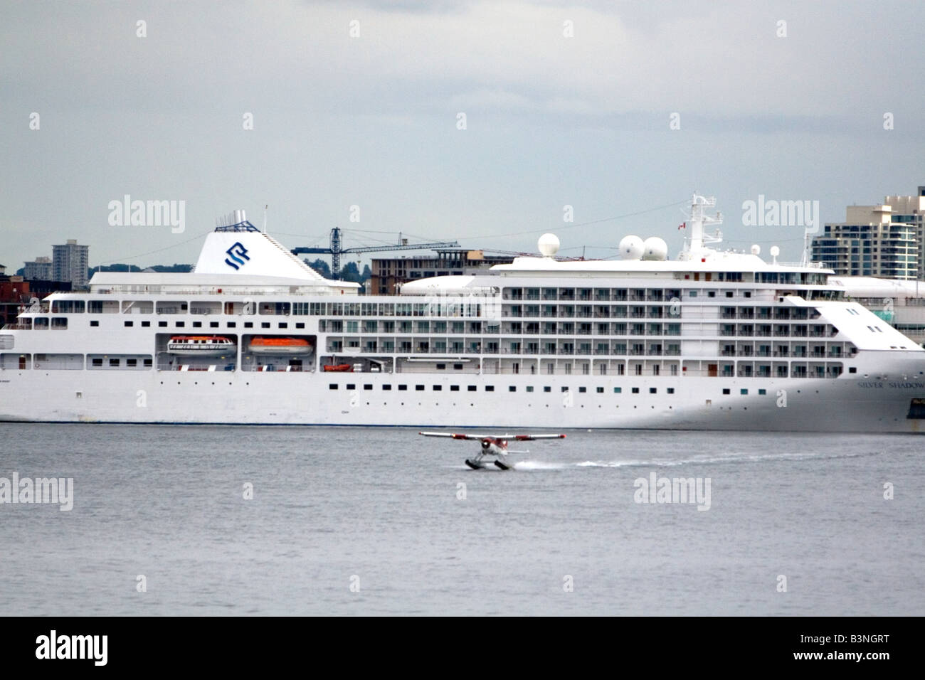 Seaplane taking off in front of the Silversea Silver Shadow cruise ship