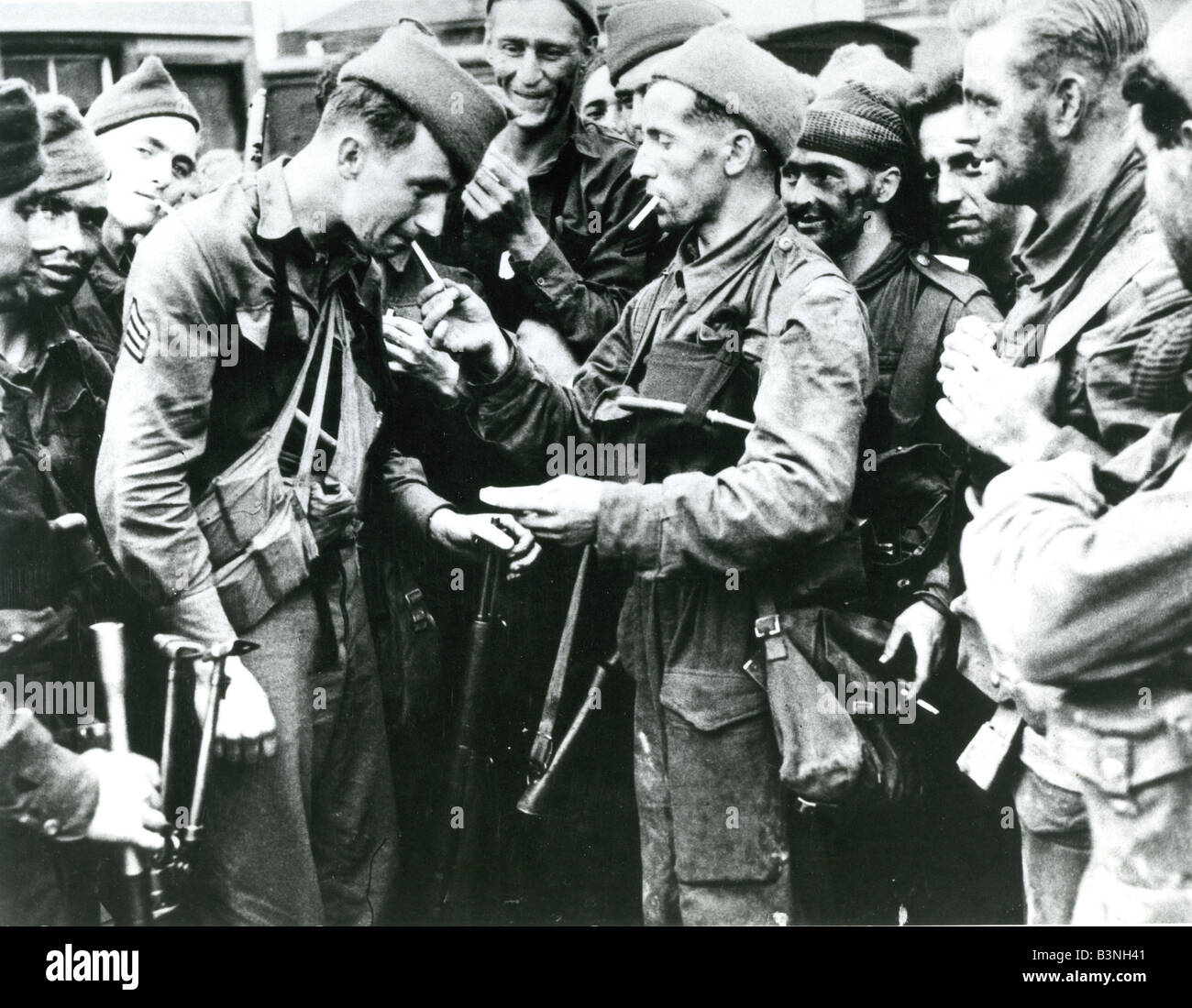 DIEPPE RAID - August 1942. A British Commando at right gives a cigarette to an American Ranger at Newhaven after their return Stock Photo