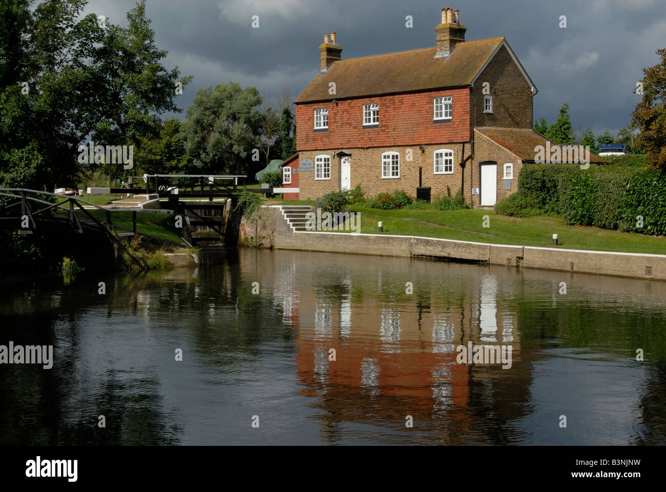 Lock keeper's cottage at Stoke Lock reflected in River Wey Navigation, just outside Guildford, Surrey, England Stock Photo