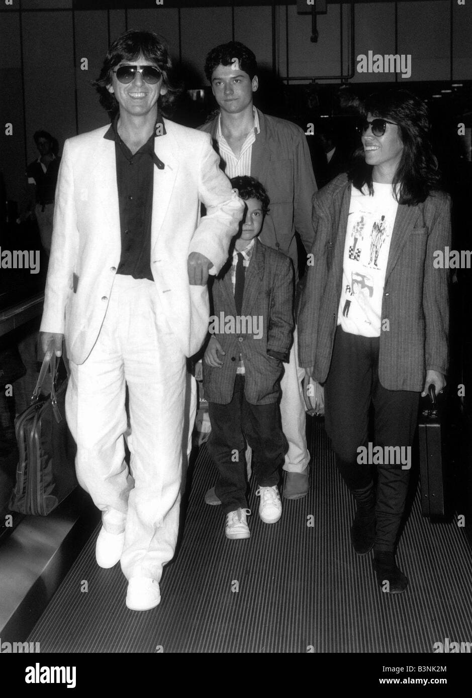 Former Beatles singer and guitarist George Harrison and family with a child  of a friend at Heathrow airport August 1986 Stock Photo - Alamy