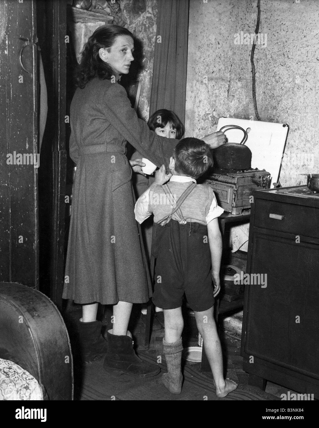 A Birmingham housewife seen here with her family in the kitchen of her condemned terrace house January 1957 Stock Photo