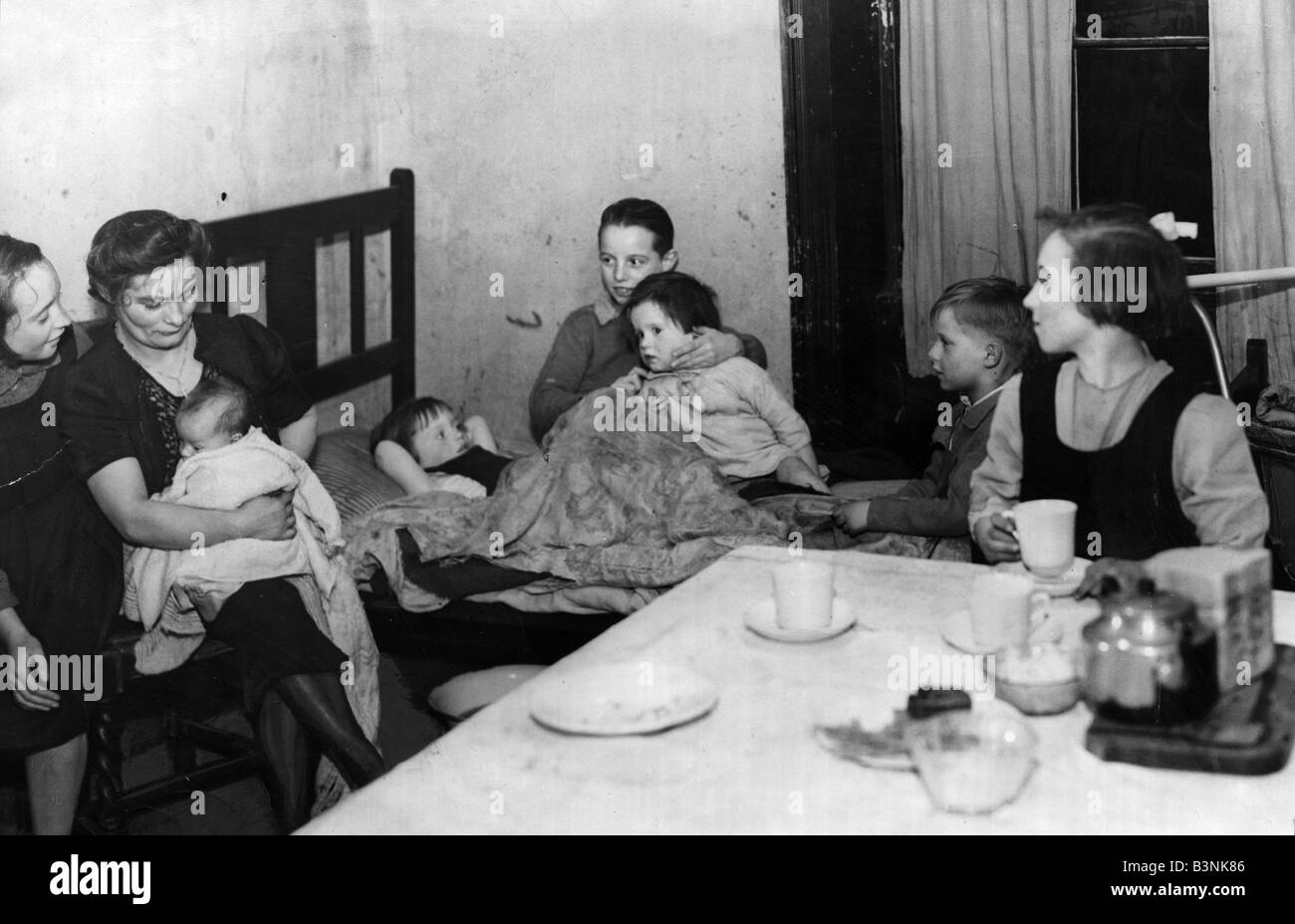 A mother and her family seen here living in one room of a Liverpool Terrace slum November 1948 Stock Photo