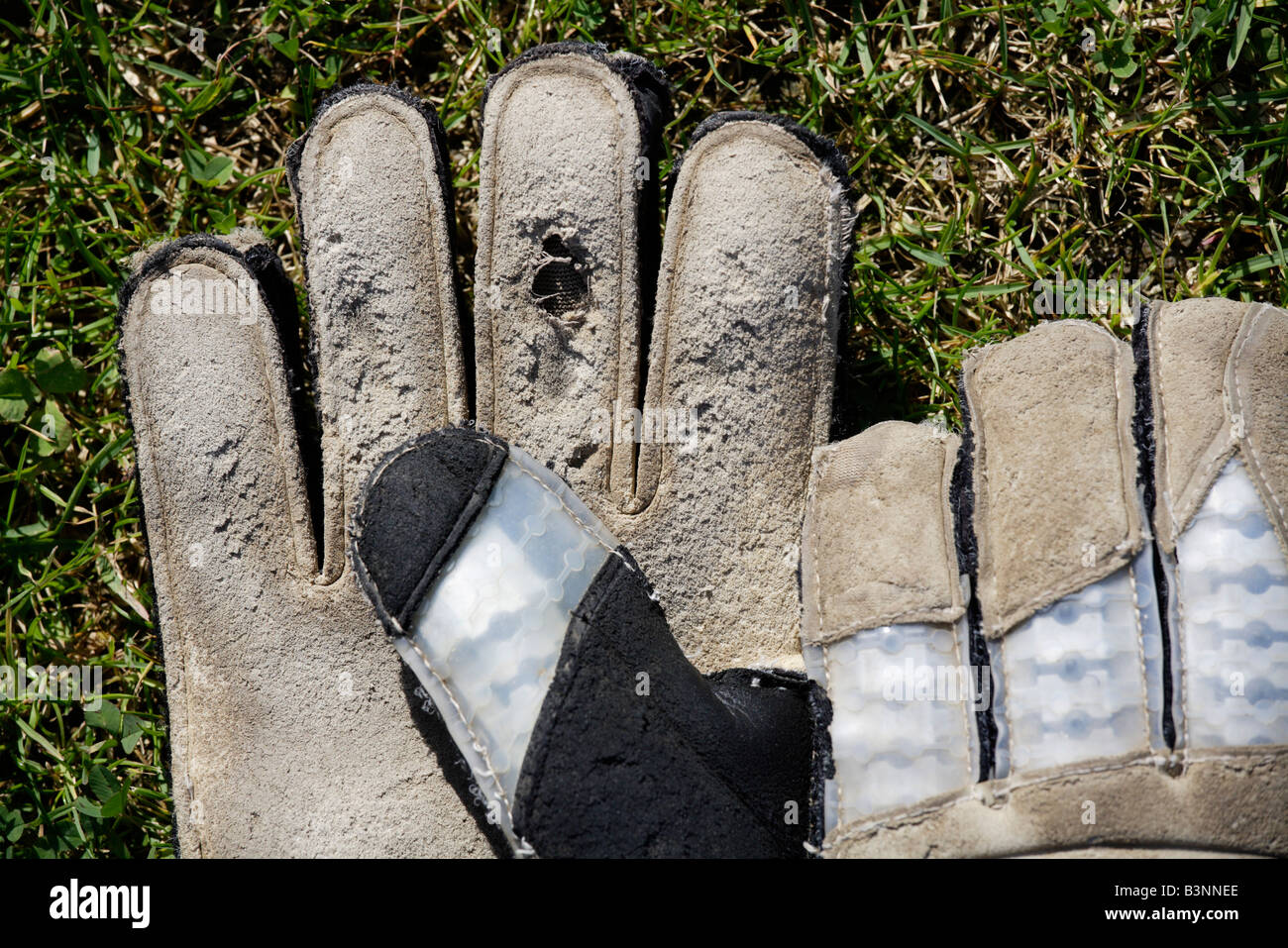Gloves of a goalkeeper lying on grass Stock Photo