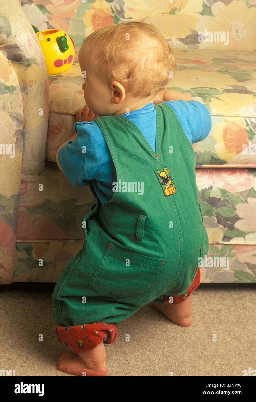 baby learning to pull himself up with help of a chair Stock Photo Alamy