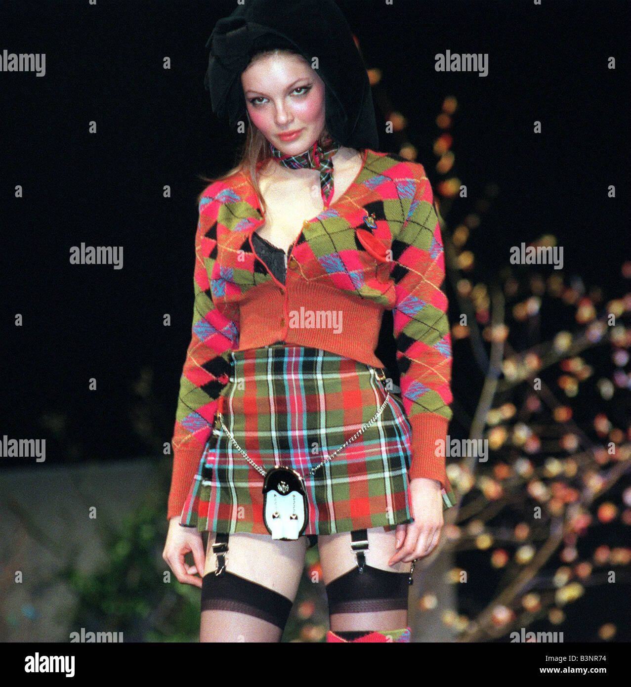Vivienne Westwood Fashion Show Glasgow January 1999 Model wears tartan mini kilt cardigan stockings and suspenders sporran Stock Photo