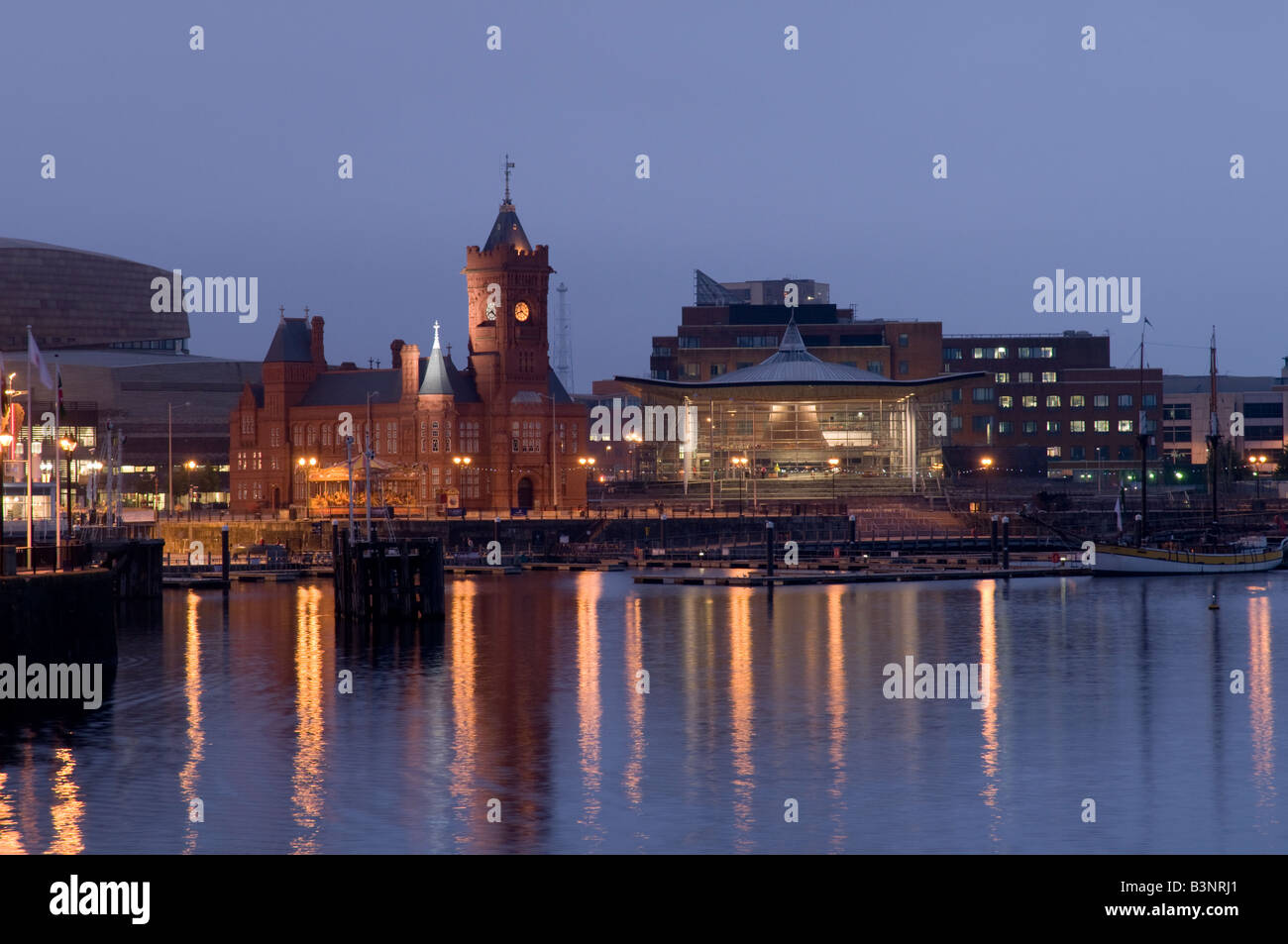Redeveloped Cardiff bay at night with the Wales Assembly Government Senedd building and Pierhead reflected in the water , UK Stock Photo