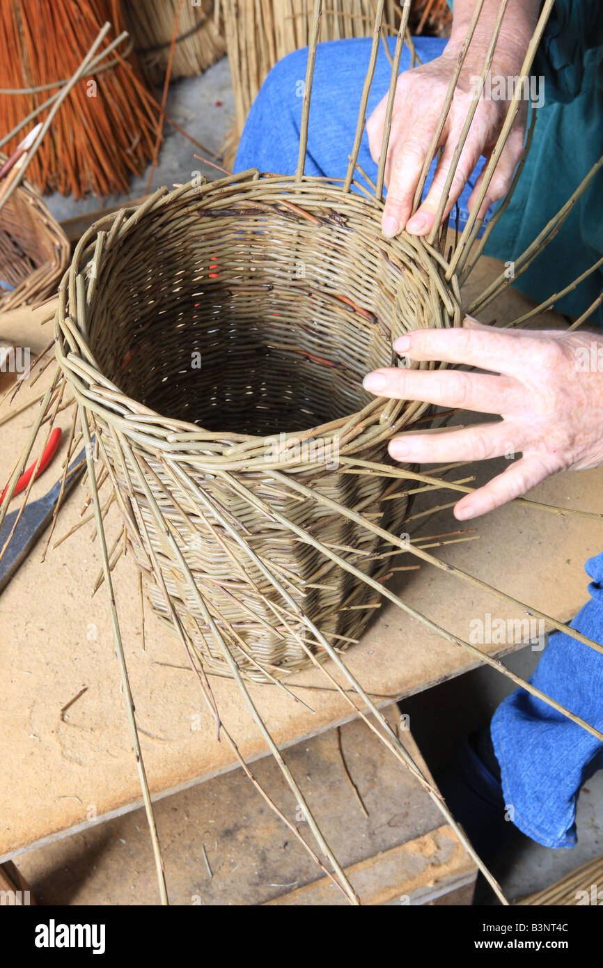 Norah Kennedy making a traditional willow basket in her workshop in The Stroud Valley Gloucestershire England Stock Photo