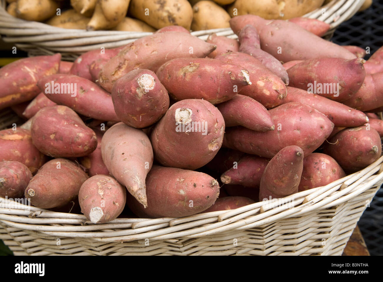 Two baskets of sweet potatoes (yams) for sale at an outdoor market Stock Photo