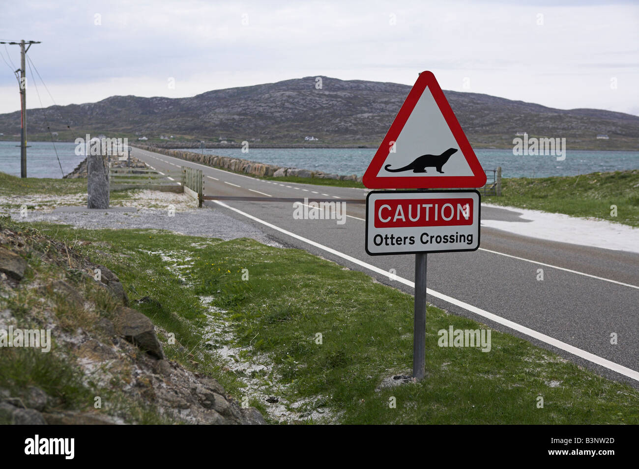 Caution Otters Crossing warning sign on causeway between South Uist and Eriskay, Scotland in May (taken from Eriskay side). Stock Photo