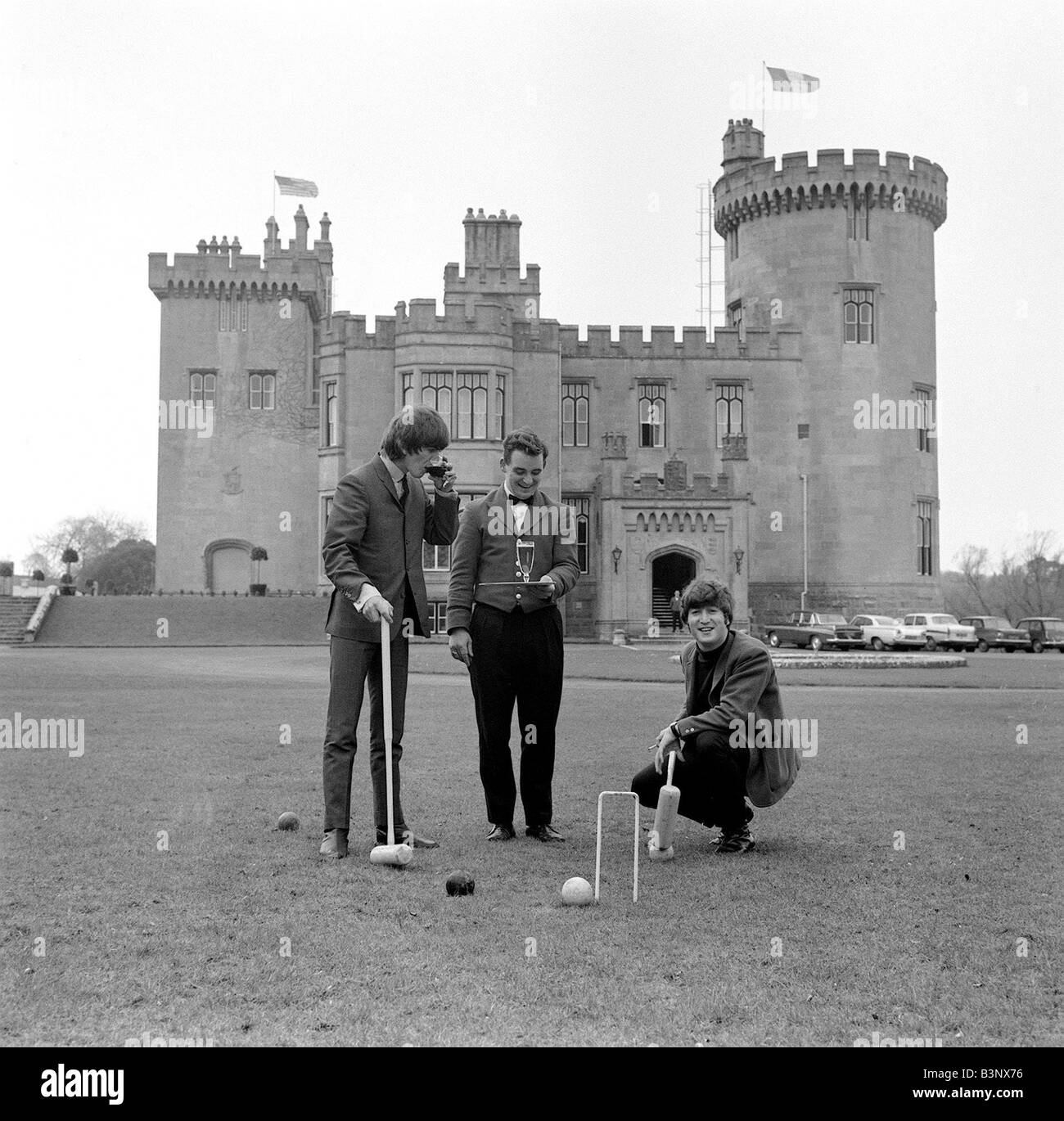 The Beatles March 1964 John Lennon and George Harrison playing croquet in the grounds of Dromoland Castle in Ireland Stock Photo