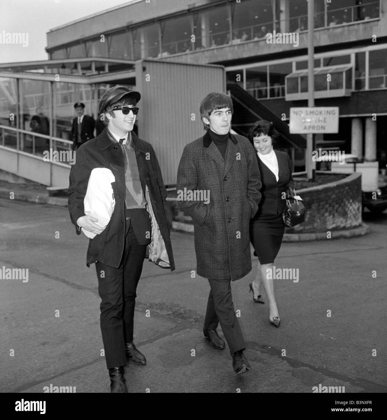 John Lennon and George Harrison of the Beatles pop group at the airport before leaving for Paris January 1964 Stock Photo