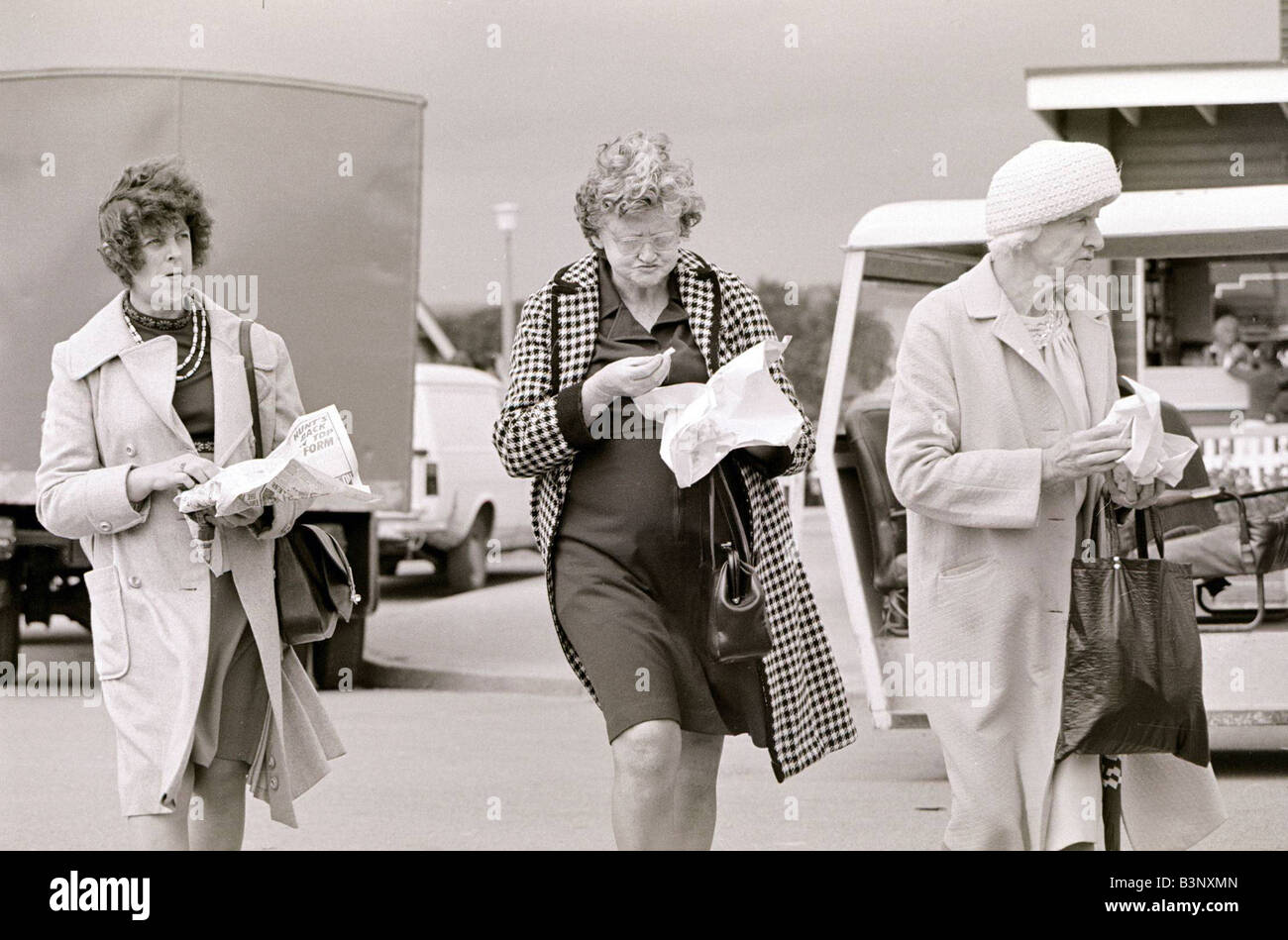 Three ladies eating chips at Trecco Bay south Wales Ugly old women eating bag of chips August 1977 Stock Photo