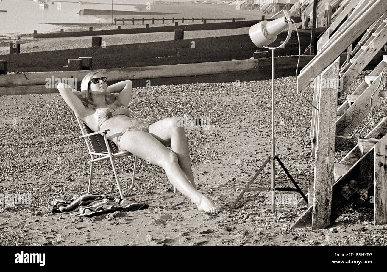 A model sunbathing under a UV lamp on the beach at Cleethorpes November 1967 Stock Photo