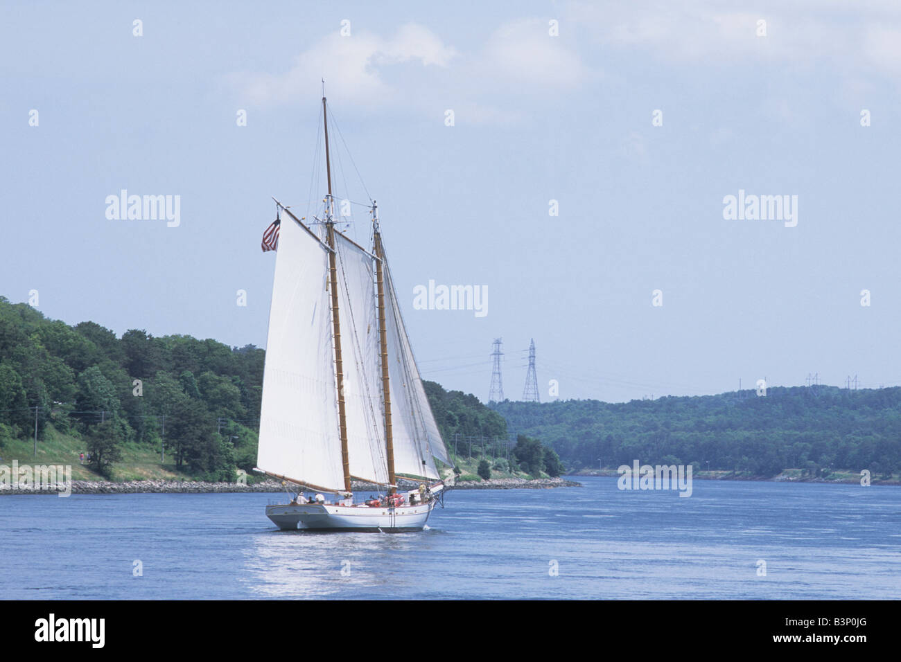 Gaff rig schooner sailing through Cape Cod Canal with full white sails Stock Photo
